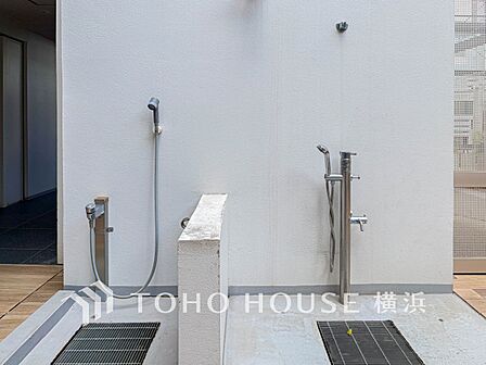 サーフィン後に便利な屋外シャワーと、ペット足洗い場を完備。湘南での日常を快適に支える共用設備。