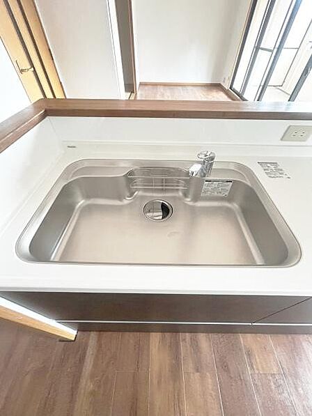 シンプルなデザインのキッチンシンクが特徴です。広々とした作業スペースが確保されておりお手入れも簡単にできます。カウンター部分も使いやすく実用性が感じられます。コンセントも設置されているので便利です。
