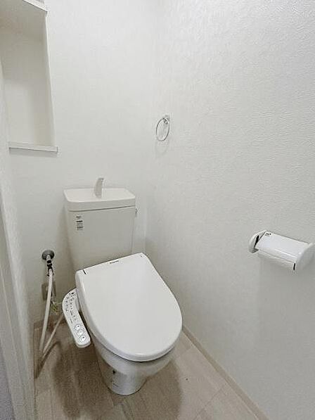 白を基調とした内装で清潔感が感じられるトイレです。コンパクトな設計でスペースを有効活用しています。ウォシュレット機能が設置されており日常に便利さがプラスされています。