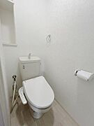 白を基調とした内装で清潔感が感じられるトイレです。コンパクトな設計でスペースを有効活用しています。ウォシュレット機能が設置されており日常に便利さがプラスされています。