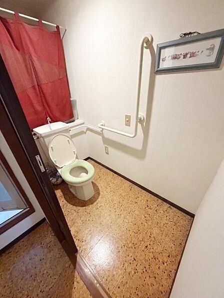 【一部AIモノ消し済み・実際の室内状況優先】手すりが設置されたトイレは動作をサポートしやすい仕様になっています。明るい床材を採用し清潔感のある印象です。