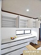 白を基調とした清潔感あふれる大容量のカップボード。豊富な吊り戸棚や引き出しで、食器類をすっきり収納できます。