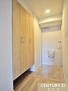 木の温もりを感じるナチュラルテイストな玄関。天井まである大容量のシューズボックスを備え、ご家族の靴をすっきりと収納できます。