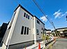 外観：白い外壁の2階建て住宅と前面道路