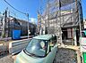 外観：建築中の建物と前面道路、車両の様子