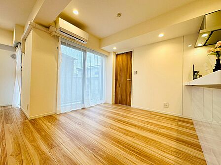 木目調床の明るいリビングとキッチンが見える空間