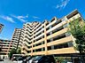 外観：複数階建てのマンションの外観、青空の下に立地