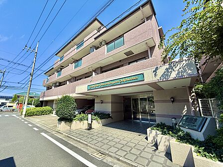 複数階のマンション外観、周囲に緑も見える