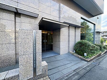 建物のエントランスと周囲の植栽が見える外観写真