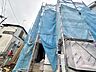 外観：建築中の建物で外装に足場と養生シートが設置されている様子です
