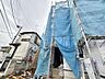 外観：建築中の住宅外観、青い養生シートで覆われています