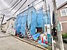 外観：青い養生シートで覆われた建築中の建物