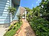 外観：植栽に囲まれた建物脇の通路