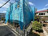 外観：青い養生シートで覆われた建物と前面道路
