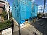 外観：青い養生シートで覆われた建物と前面道路