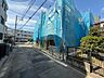 周辺：建設中の建物を囲う青い防護シートと周辺道路
