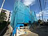 外観：青い養生ネットで覆われた建築中の建物