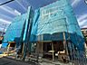 外観：青いメッシュで覆われた建築中の建物外観