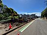 周辺：道路沿いの工事中の敷地と周辺の山並み