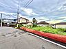 周辺：赤いガードレール沿いの住宅街の道路