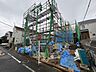 外観：建築中の建物を囲む足場と周辺道路