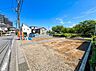 外観：道路沿いの整形地周囲に住宅と緑が見える