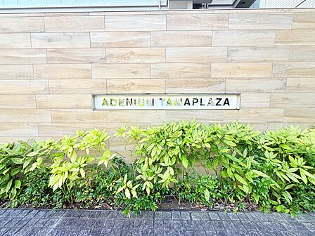 植栽と建物名プレートがある外構