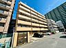外観：高層マンションが並ぶ道路沿いの外観
