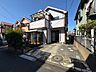 外観：住宅街に立つ戸建て住宅と前面道路