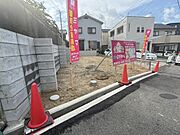現地土地写真は整った区画が特徴です。周囲には建物があり住宅街の一角に位置しています。前面道路に面しているため車の出入りもしやすい印象です。土地の状態も把握しやすく現地の様子がよく分かる写真です。