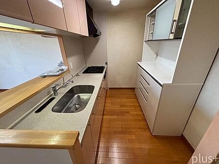 キッチン背面にはカップボードを備え、食器や調理家電をすっきり収納。必要なものに手が届きやすく、毎日の料理がしやすいキッチンスペースです。