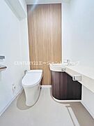 シンプルながらも清潔感を感じる空間です。木目調のデザインがアクセントになっています。洗面台とトイレが使いやすく配置されています。ゆとりある広さが魅力的です。