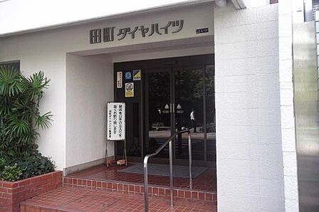 エントランスが広々としており開放的な印象を与えます。周囲の植栽が落ち着いた空間を引き立てます。外観の直線的なデザインがすっきりとした印象です。