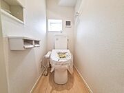 明るい色調の内装で清潔感のあるトイレです。窓があり換気もしやすい空間です。ペーパーホルダーや収納棚も設置されています。床材もお手入れしやすい仕様です。