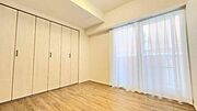 大きな窓から明るい陽光が差し込む開放感のある洋室。幅広クローゼット付きで収納も充実しており、メインの寝室としても十分な広さです。
