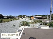 開放感のある現地土地写真です。周辺には住宅が点在しており落ち着いた雰囲気が広がっています。前面道路に接しており交通の便にも配慮されています。日当たりのよい立地で活用の幅も期待できます。