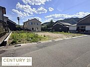 広々とした現地土地写真です。前面道路がしっかり確保されており周囲には住宅が立ち並びます。平坦な地形で整った区画が特徴的です。周辺環境の落ち着いた雰囲気も感じられます。
