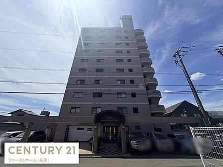 堂々とした外観が印象的なマンションです。エントランス部分も広々としています。周囲には駐車スペースも確保されています。バルコニーが各戸に設けられている構造も特徴です。青空に映える外観が魅力的です。