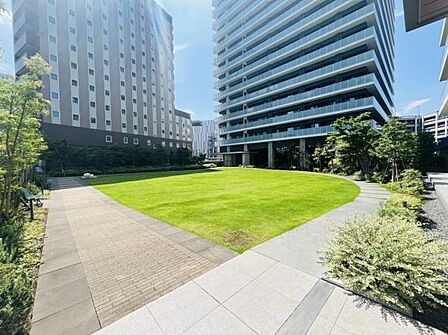 駅近の利便性と豊かな緑が調和した、洗練された空間。広々とした芝生広場が、高層マンションを背景のなかにオアシスとして日々の生活に開放感と癒しをもたらしてくれます。手入れされた散策路もありとても快適です！