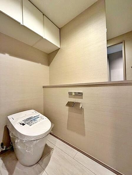 【トイレ】上部に収納棚を設けたトイレ。トイレットペーパーや清掃用品をすっきり収納でき、空間を広く使えます。
