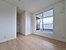 洋室：明るい色合いのフローリングが印象的な洋室です。大きな窓からバルコニーへとつながり開放感があります。ナチュラルな雰囲気が魅力です。