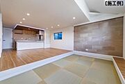 【同社施工例】広々としたリビングが印象的な空間です。キッチンと畳スペースが自然に調和しています。明るい照明で開放感があります。落ち着いた色合いの壁がアクセントになっています。