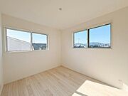 複数の窓から自然光がたっぷりと入る洋室です。木目調のフローリングが部屋全体の印象をすっきりと引き立てます。
