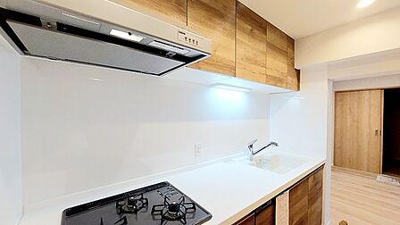 壁付のキッチンは上部に収納が作りやすいのがメリット。空間を有効活用したすっきりとしたデザイン。