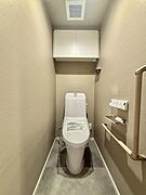 ウォシュレット機能付きのトイレ。収納もあり実用性も兼ね備えた造り。 