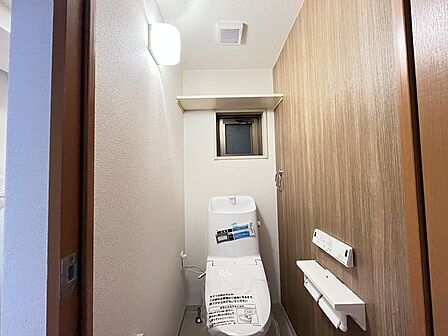 ウォシュレット機能付きのトイレ。換気のしやすい窓付きで、収納もあり実用性も兼ね備えた造り。